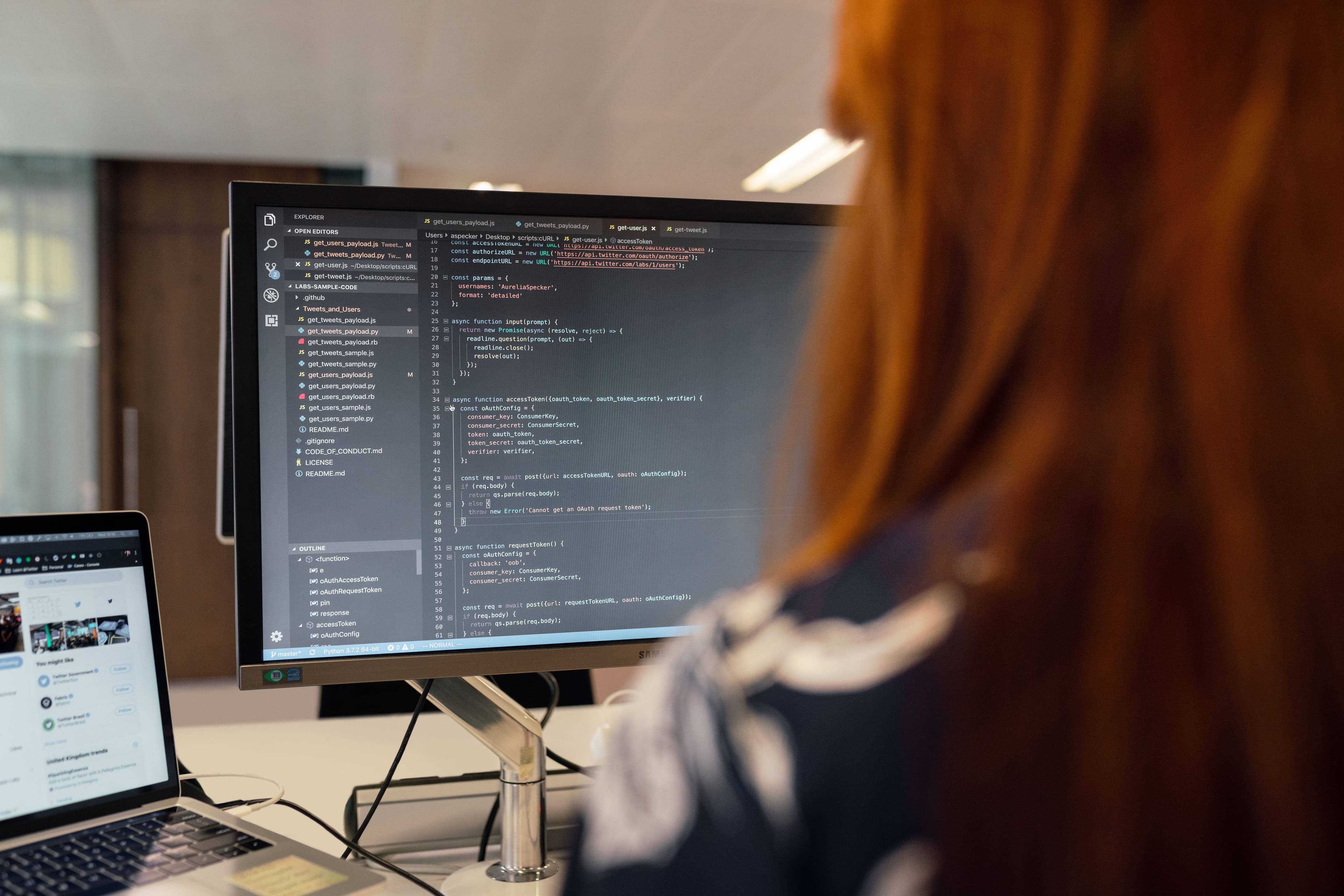 Software developer looking at computer screen with code
